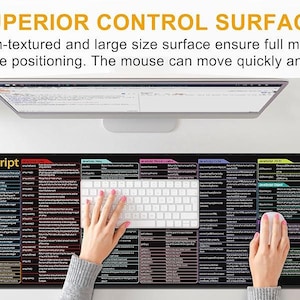 May include: A black and multi-colored JavaScript mouse pad with a white keyboard and a pink mouse. The mouse pad has a large surface area and includes the text "SUPERIOR CONTROL SURFACE". A smartphone, tablet, and coffee cup are also visible.