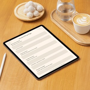 Może przedstawiać: Tablet cyfrowy wyświetlający układ "Session Prep Page", wraz z białym rysikiem, drewnianą tacą ze szklanką wody, filiżanką latte i małym drewnianym talerzem z cukierkami kokosowymi. Scena jest ustawiona na drewnianej powierzchni.