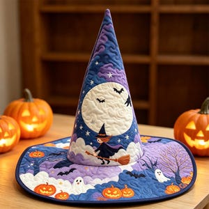 Pode incluir: Um chapéu de bruxa acolchoado com um padrão de céu noturno em azul escuro e roxo, uma grande lua branca, morcegos, fantasmas e abóboras laranjas. O design inclui uma figura central de uma bruxa voando numa vassoura contra a lua.