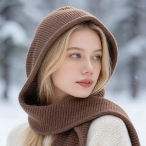 May include: A brown knit hood and scarf set. The hood is designed to be worn over the head, with a scarf that can be wrapped around the neck. The set is made of a soft, textured knit material, perfect for cold weather.
