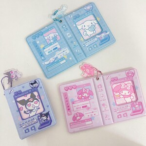 May include: Three open, rectangular card holders in blue, lavender, and pink. Each features a cartoon character design with matching keychains. The blue holder has a white dog character, the lavender has a black cat, and the pink has a pink character.