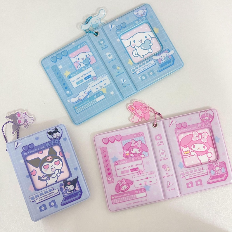 May include: Three open, rectangular card holders in blue, lavender, and pink. Each features a cartoon character design with matching keychains. The blue holder has a white dog character, the lavender has a black cat, and the pink has a pink character.