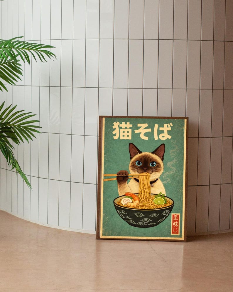 May include: A framed poster featuring a Siamese cat enjoying ramen noodles. The cat, with blue eyes and a black mask, is holding chopsticks. The poster has Japanese text and a vintage aesthetic, with a teal background and a brown frame.