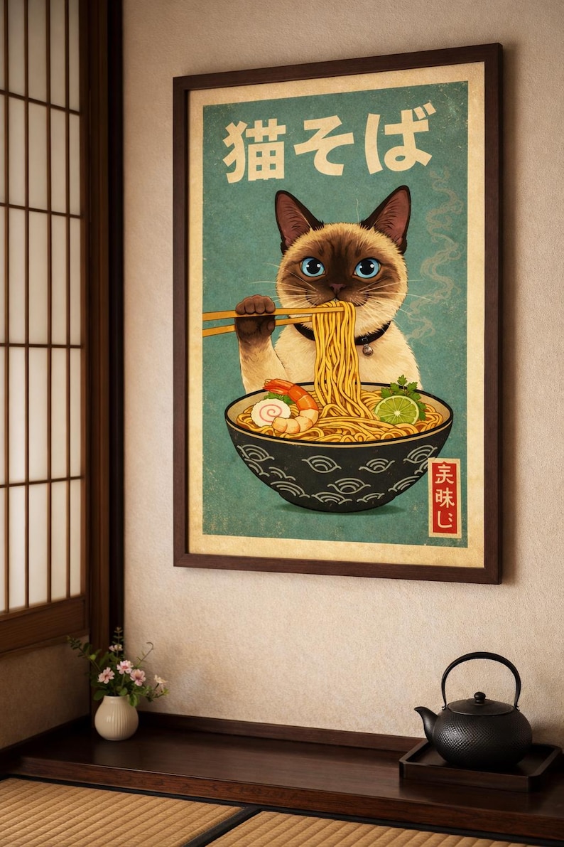 May include: A framed poster featuring a Siamese cat enjoying ramen. The cat, with blue eyes, holds chopsticks above a bowl of noodles, shrimp, and lime. Japanese text is at the top. The poster has a vintage aesthetic with a teal background.