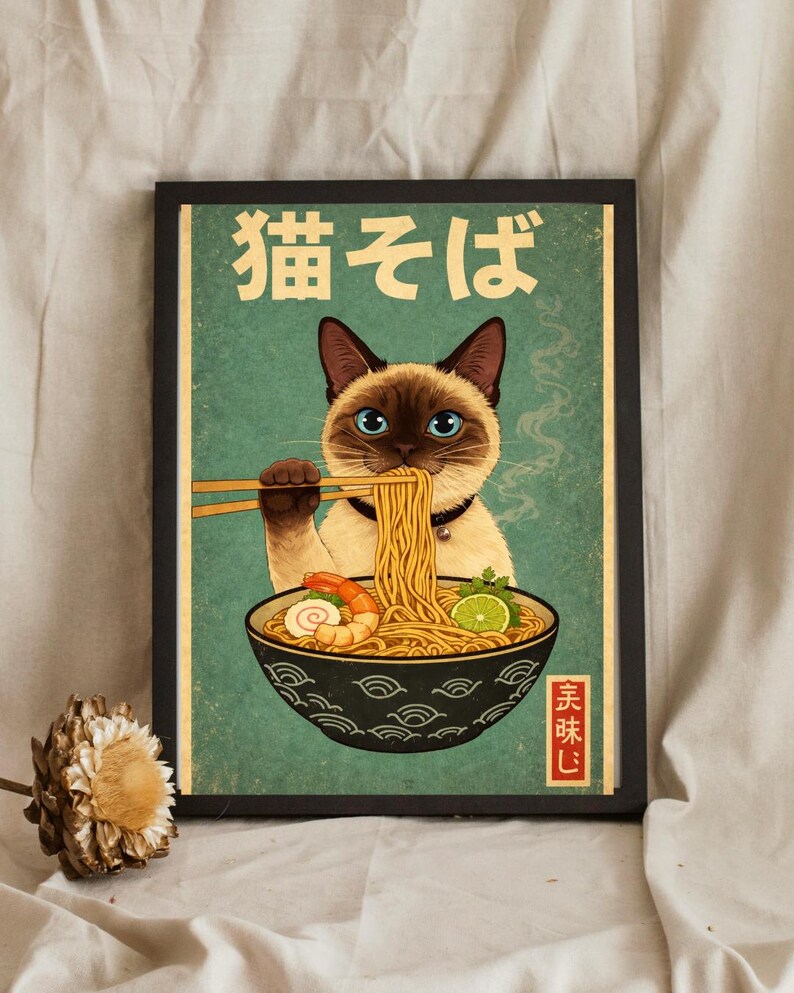 May include: A framed print featuring a Siamese cat enjoying ramen noodles with chopsticks. The cat is depicted with blue eyes and a black collar. The bowl of ramen includes shrimp and lime. The Japanese text "猫そば" is at the top.