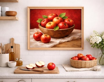 May include: A framed still life painting of apples in a wooden bowl, with several apples scattered around. A basket of apples and cut apples on a cutting board are also visible. The scene is set in a kitchen.