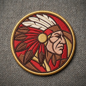 May include: Embroidered patch featuring a Native American chief in profile, with a headdress of red, brown, and white feathers. The design is circular, with a gold border and a red background. The chief's face is detailed with tan and brown tones.