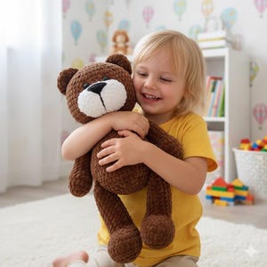May include: A brown crocheted teddy bear with a white muzzle and black nose is being hugged. The bear has a textured appearance. The child is wearing a yellow shirt. The background features a wallpaper with colorful hot air balloons.