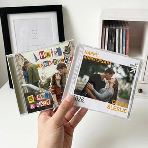 May include: Two clear CD cases with custom photo inserts. One case reads "Happy Anniversary" with a photo of a couple kissing. The other case reads "Happy Anniversary" with a photo of a couple. The names "Shawn & Mary" and "Diana & Leslie" are also visible.