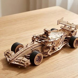 Pode incluir: Uma caneca de cerâmica branca com uma alça preta e o texto "But First, Coffee" em estilo manuscrito. A caneca está sobre uma superfície branca. Perfeita para café ou chá.