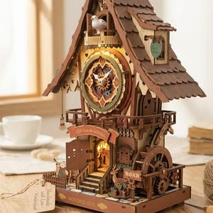May include: A wooden cuckoo clock with a detailed design. The clock features a bird on a balcony, a clock face with visible gears, and the text "Fall down the rabbit hole". The clock is brown with light brown and green accents.