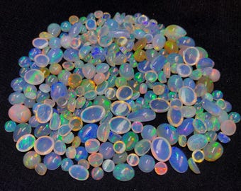 May include: A collection of opals in various shapes and sizes, showcasing a spectrum of colors including blue, green, orange, and pink. The opals are set against a black background, highlighting their iridescent qualities.