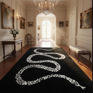May include: A black rug featuring a white snake design, placed in a hallway. The rug's snake pattern is a striking contrast against the dark background. The hallway has wooden flooring, white walls, and decorative elements.
