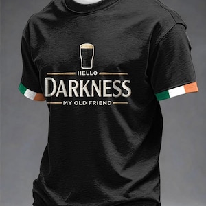 Puede incluir: Camiseta negra con la frase "HELLO DARKNESS MY OLD FRIEND" y un gráfico de una pinta de cerveza. Las mangas tienen rayas verdes, blancas y naranjas. Una prenda de vestir informal.