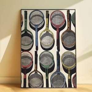 May include: Framed art print featuring a repeating pattern of vintage tennis rackets in various colors, including green, blue, yellow, and red. The rackets are set against a cream-colored background, creating a retro sports theme.