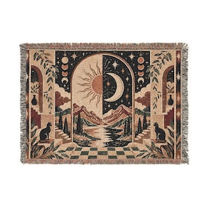 Peut inclure: Un plaid tissé rectangulaire présentant une arche centrale divisée entre un soleil et une lune. Le motif comprend des montagnes, une rivière, deux chats noirs assis sur des escaliers et un sol en damier, dans des tons de noir, beige et rouille.