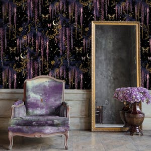 May include: A room featuring a purple velvet armchair, a large gold-framed mirror, and a dark floral wallpaper with wisteria, butterflies, and moons. A vase of purple flowers sits near the mirror. The floor is tiled.