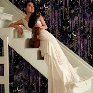 May include: A woman in a cream-colored dress sits on a white staircase, holding a violin. The background features a dark, patterned wallpaper with purple wisteria, butterflies, and celestial elements. The violin is a warm brown color.