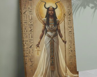 May include: Canvas art print depicting an Egyptian goddess with dark skin, wearing a white dress, gold jewelry, and a headdress with horns. She holds an ankh and a staff. The background features hieroglyphs and a golden halo.