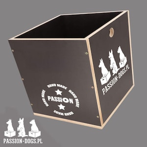 Op de afbeelding: Een zwarte houten opbergdoos met een schuine bovenkant en een natuurlijke houten rand. De doos heeft witte afbeeldingen van honden en de tekst "PASSION-DOGS.PL" en "HAND MADE PASSION". Er is een gat aan de zijkant geboord.