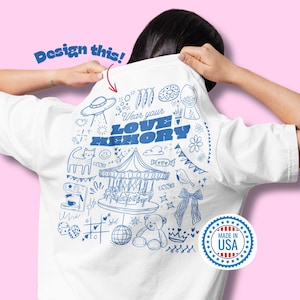 Può includere: T-shirt bianca con un disegno blu scarabocchiato sul retro, con una giostra, un gatto e altre illustrazioni stravaganti. Il testo "Wear your LOVE MEMORY" è ben visibile. È visibile un sigillo "Made in USA".