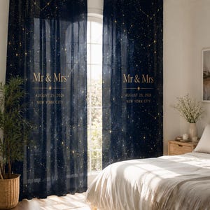 May include: A pair of navy blue curtains featuring a gold celestial star map pattern. The text "Mr & Mrs", "AUGUST 25, 2026", and "NEW YORK CITY" is printed in gold on each panel. The curtains are sheer, allowing light to pass through the fabric.