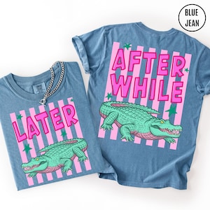 Puede incluir: Dos camisetas vaqueras azules con texto rosa y un gr&aacute;fico de cocodrilo verde. Una camiseta dice "LATER" y la otra dice "AFTER WHILE". Las camisetas tienen fondos a rayas rosas y blancas con acentos de estrellas verdes.