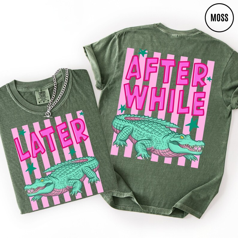 Puede incluir: Dos camisetas verde musgo con un dise&ntilde;o de rayas rosas y blancas. Una camiseta dice "LATER" y la otra "AFTER WHILE" en letras rosas. Cada camiseta presenta un gr&aacute;fico de un caim&aacute;n turquesa.
