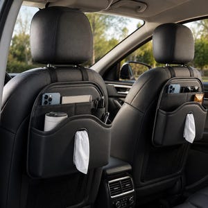 Könnte beinhalten: Zwei schwarze Auto-Rücksitz-Organizer, die an der Rückseite der Vordersitze befestigt sind. Jeder Organizer verfügt über mehrere Staufächer, darunter ein spezielles Fach für eine Taschentuchbox mit weißen Taschentüchern, ein Telefon und Stifte.