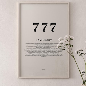 K&ouml;nnte beinhalten: Ein gerahmter Wandkunstdruck mit der Zahl 777 in gro&szlig;er schwarzer Schrift, dem Text I AM LUCKY und einem Absatz, der die Bedeutung der Zahl erkl&auml;rt. Das Design ist auf einem hellbeigen Hintergrund mit einem einfachen hellen Holzrahmen gedruckt.