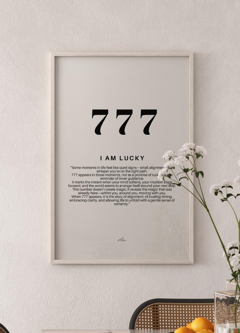 K&ouml;nnte beinhalten: Ein gerahmter Wandkunstdruck mit der Zahl 777 in gro&szlig;er schwarzer Schrift, dem Text I AM LUCKY und einem Absatz, der die Bedeutung der Zahl erkl&auml;rt. Das Design ist auf einem hellbeigen Hintergrund mit einem einfachen hellen Holzrahmen gedruckt.
