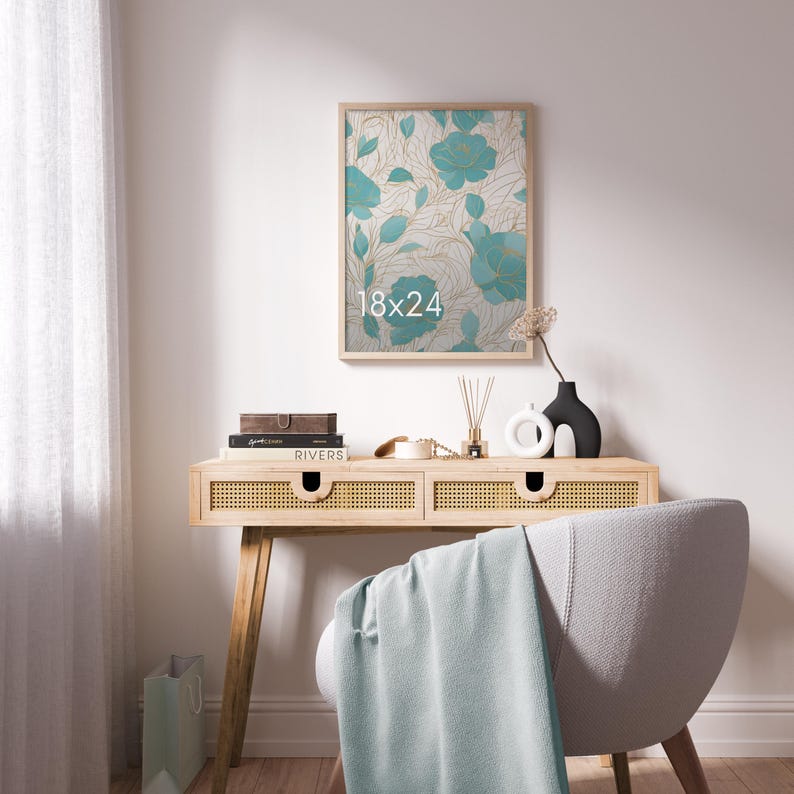 May include: A rectangular wall art print in a light wood frame featuring a teal floral pattern with gold line accents and the text 18x24. The artwork is displayed above a light wood console table with cane drawer fronts and a light blue throw.