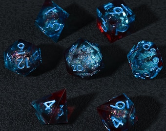 Könnte beinhalten: Ein Satz von sieben polyedrischen Würfeln in transparentem Blau mit roten Akzenten und Glitzer. Jede Seite der Würfel hat weiße Zahlen. Die Würfel sind für Rollenspiele geeignet und liegen auf einer dunklen Oberfläche.