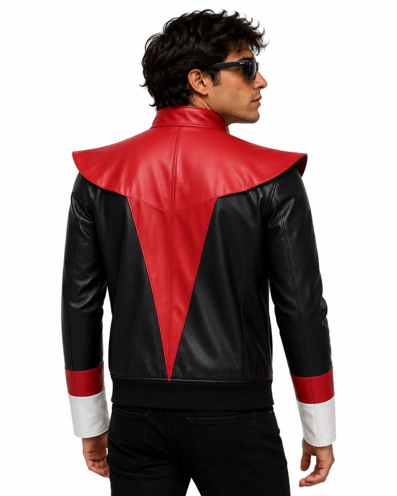 May include: A black and red jacket featuring a high collar and a prominent red V-shaped panel on the back. The sleeves have red and white cuffs, and the hem is finished with a black ribbed band. The jacket is constructed from smooth material.