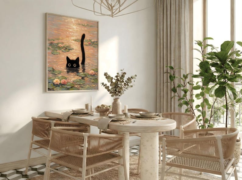 Puede incluir: Una impresi&oacute;n enmarcada representa un gato negro en un estanque con nen&uacute;fares y flores. La obra de arte cuelga sobre una mesa de comedor de madera clara con sillas de mimbre. Un jarr&oacute;n con vegetaci&oacute;n y una planta en maceta completan la decoraci&oacute;n.