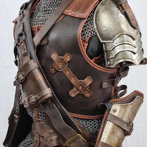 Op de afbeelding: Een middeleeuwse stijl harnasset van bruin leer en metaal. Het leren borststuk heeft kruisvormige accenten, schouderbeschermers en een holster. Kogelvrij vest en een metalen schouderplaat zijn ook zichtbaar.