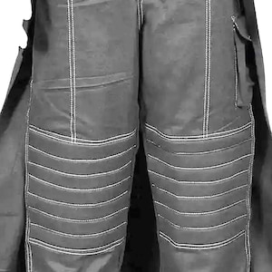 May include: Close-up of dark gray pants with white stitching. The pants have a quilted design on the knees and a pocket on the right leg. The pants are part of a larger outfit, with a coat visible on the sides.