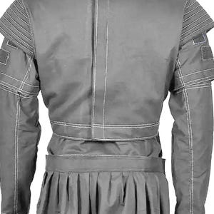May include: A gray jacket and skirt set. The jacket features structured shoulders with horizontal stitching and square patches on the sleeves. The skirt is pleated. White stitching accents the seams of the jacket.