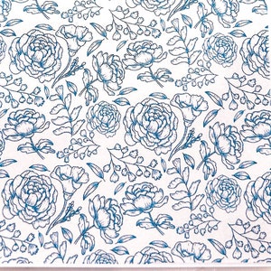 May include: A white sheet of paper with a blue floral pattern. The pattern features a repeating design of stylized flowers and leaves.