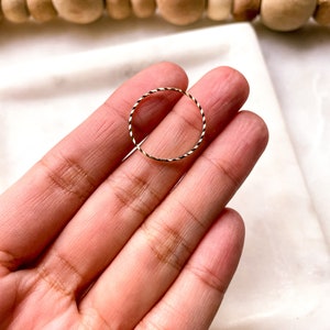 Puede incluir: Un fino anillo de oro con un diseño trenzado.