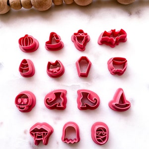 Puede incluir: Un juego de 15 cortadores de galletas de Halloween de plástico rosa. Los cortadores tienen forma de calabaza, sombrero de bruja, fantasma, murciélago, maíz dulce, gato, ataúd, caldero, calavera, zapato de bruja, momia, colmillos de vampiro y un fantasma.