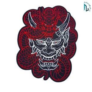 May include: An embroidered patch featuring a white and black Hannya mask design centered within a coiled red dragon. The dragon has detailed scales and horns, while the mask displays sharp teeth and intense eyes, all set against a black background.