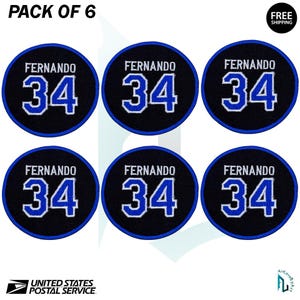 May include: Six circular patches with the name "FERNANDO" above the number "34" in white and blue. The patches are black with a blue border. The text "PACK OF 6" is at the top.