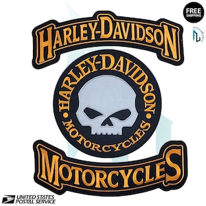 May include: Black and gold Harley-Davidson motorcycle patches. The patches include the Harley-Davidson logo, a skull, and the words "Motorcycles". The patches are likely for a jacket or vest.