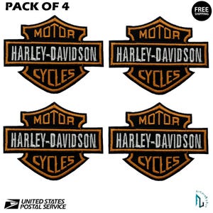 May include: Four Harley-Davidson Cycles patches. Each patch features the Harley-Davidson logo in black, orange, and white. The text "MOTOR HARLEY-DAVIDSON CYCLES" is prominently displayed. The patches are in a shield shape.