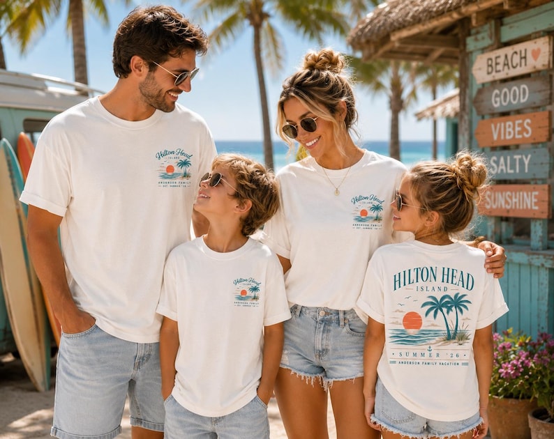 May include: A group of four people wearing matching white short-sleeve t-shirts. The shirts feature a graphic on the chest and back with the text Hilton Head Island, Summer 24, and an illustration of palm trees, a sun, and ocean waves.