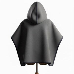 May include: A gray hooded cape with a dark blue trim. The cape is displayed on a wooden mannequin. The hood is a rounded shape and the cape has a simple, flowing design. The cape is made of a soft material.