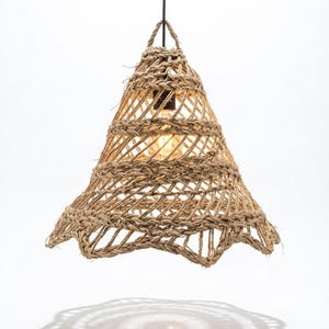 May include: A hanging pendant light fixture featuring a conical shade crafted from thick, natural-colored woven rope. The open-weave design showcases a central light bulb socket suspended by a black cord, creating a textured, bell-shaped silhouette.