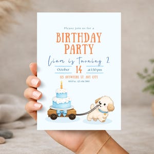 Puede incluir: Una invitación de cumpleaños azul claro con el texto "BIRTHDAY PARTY" y "Liam cumple 2". La invitación presenta un pastel sobre un carro de madera tirado por un cachorro.