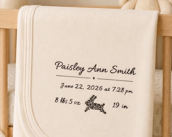 May include: A cream-coloured baby blanket featuring dark brown embroidery. The text reads: Paisley Ann Smith, June 22, 2026 at 7:28 pm, 8 lbs 5 oz, and 19 in. A small embroidered rabbit icon is positioned between the weight and length details.